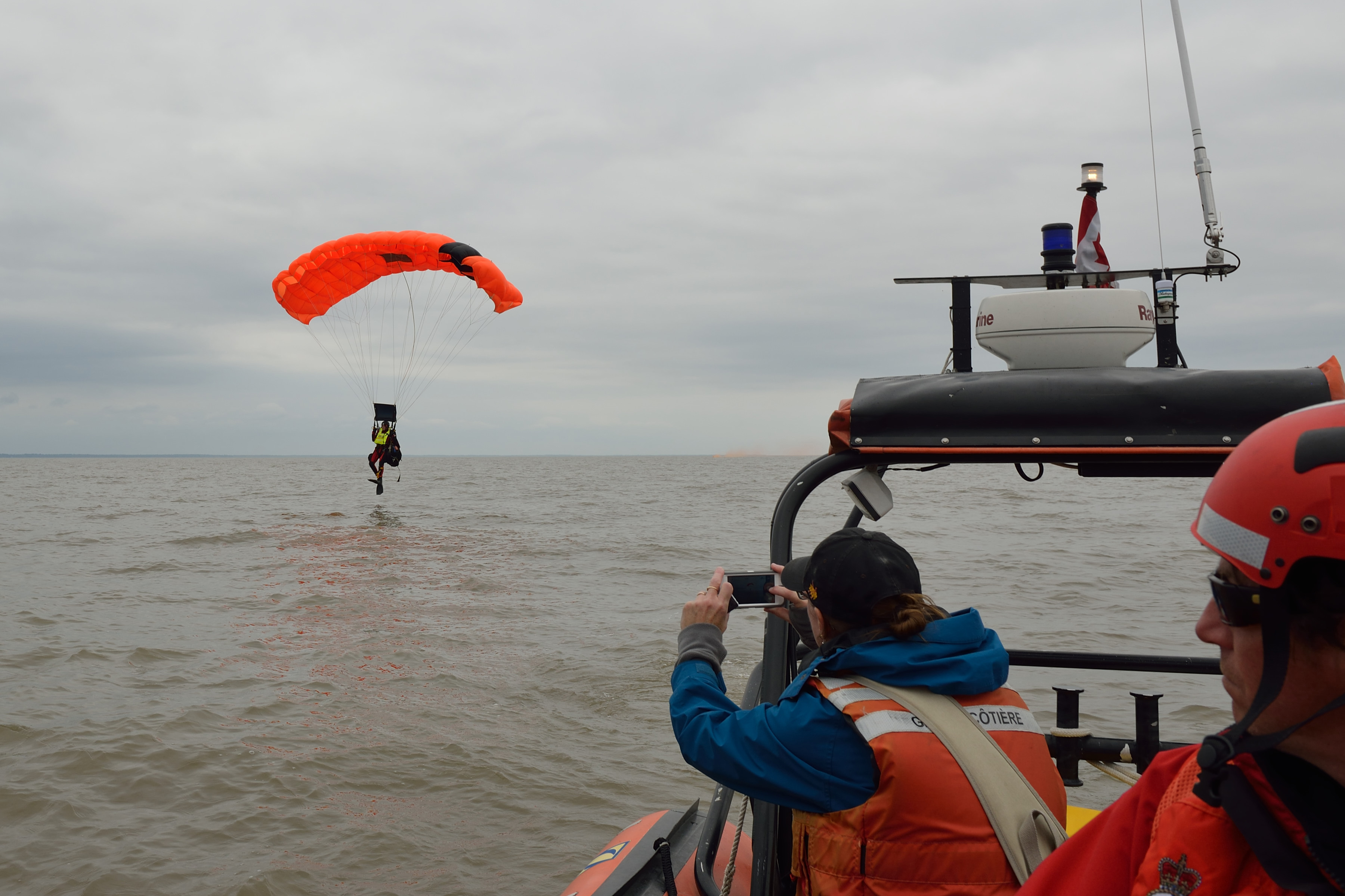 While spectators in a Canadian Coast Guard rigid hulled inflatable boat watch, Master Corporal Kent Stanway, a SAR Tech from 14 Wing Greenwood, N.S., jumps into Lake Winnipeg during the National SAREX 2013. PHOTO: Sergeant Bill McLeod