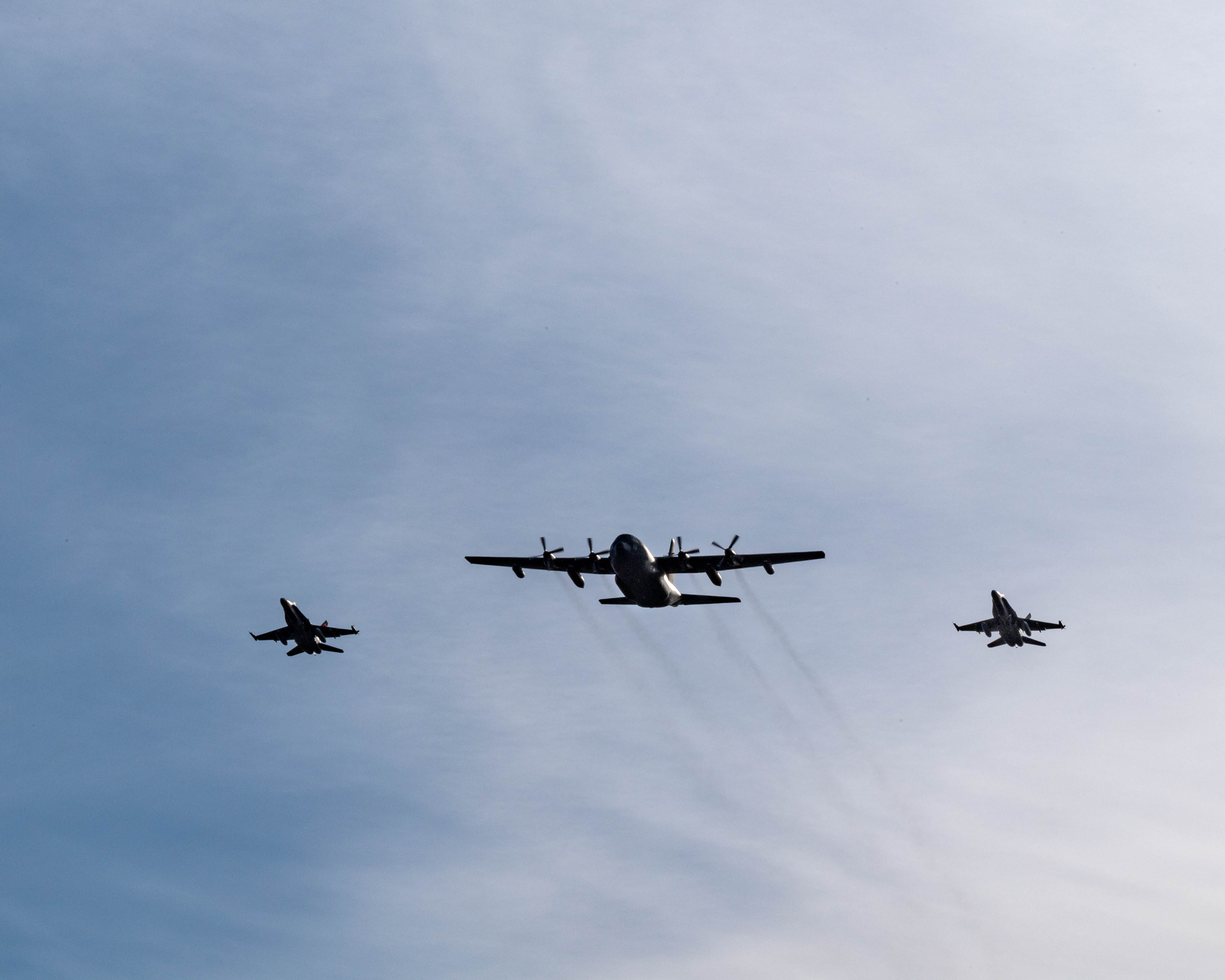 A CC-130 Hercules aircraft flies in formation with two CF-188 Hornet fighter aircraft on October 13, 2020, to mark the 60th year of service of the aircraft in the Royal Canadian Air Force. PHOTO: Corporal Darryl Hepner