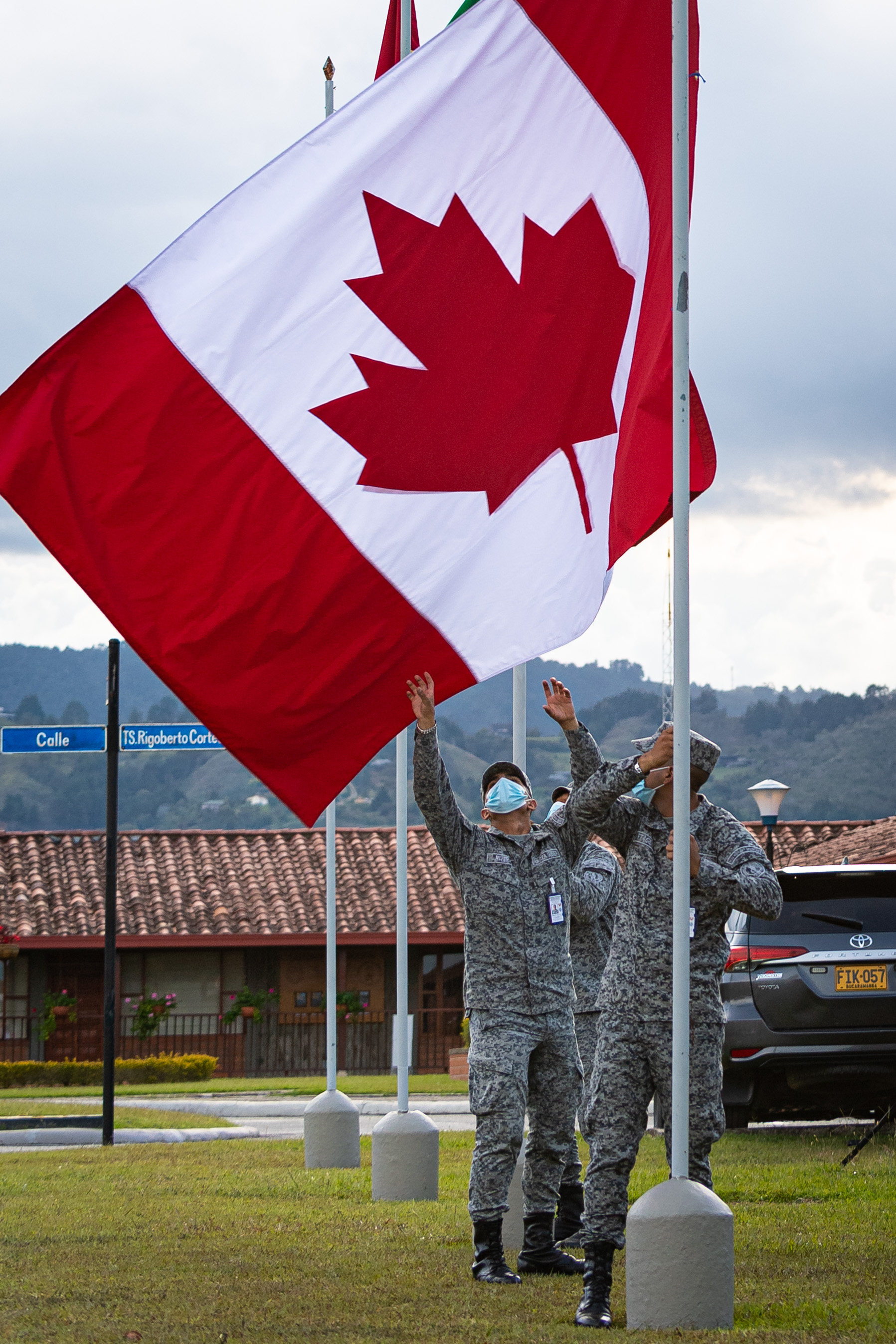 Des membres de la Force aérienne colombienne retirent le drapeau du Canada à la fin de la journée durant l’exercice COOPERACION VII à la base aérienne colombienne Arturo Lema Posada en Colombie le 3 septembre 2021. PHOTO : Caporal Dominic Duchesne-Beaulieu